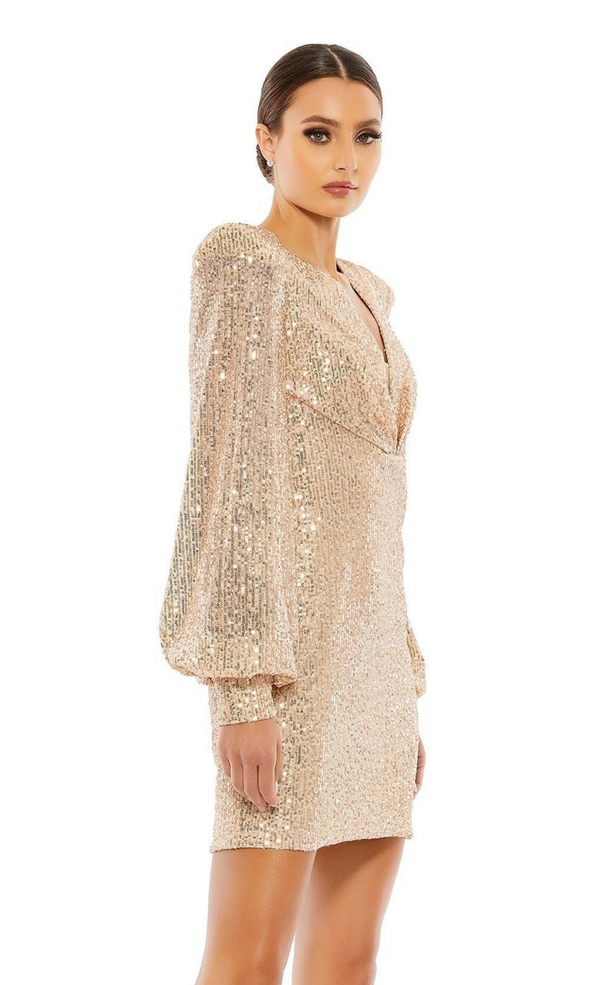 A woman stands against a white background in the Mac Duggal 26865 Long Sleeve Sequin Hoco Dress, featuring a deep V-neckline and gold shimmer—radiating glamorous, party-ready style.